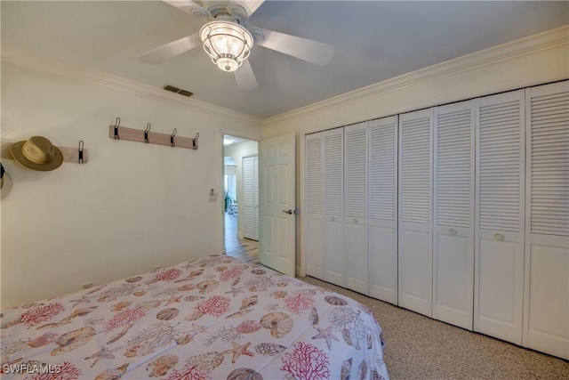 bedroom with ceiling fan, ornamental molding, a closet, and visible vents