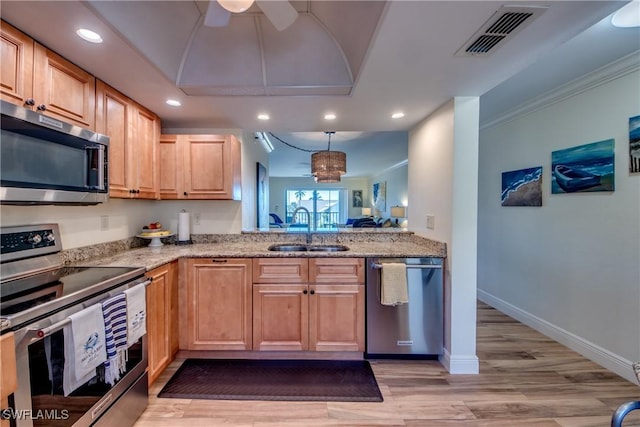 kitchen with light stone counters, recessed lighting, visible vents, appliances with stainless steel finishes, and a sink