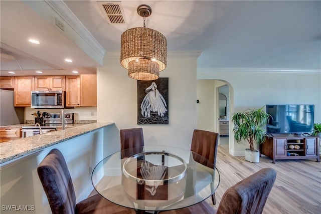 dining space featuring a chandelier, recessed lighting, visible vents, light wood-style floors, and crown molding