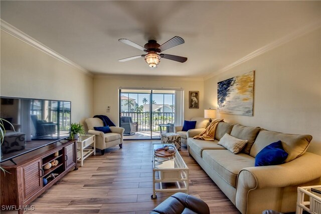 living room featuring ceiling fan, ornamental molding, and wood finished floors