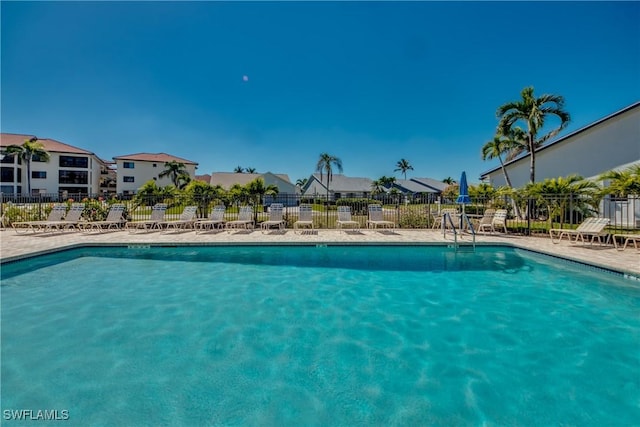 community pool featuring a residential view and fence