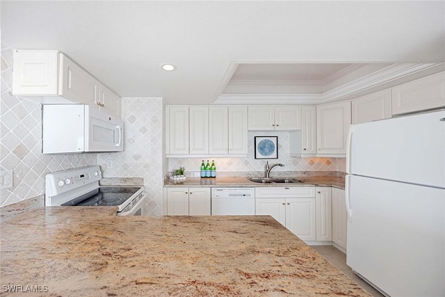 kitchen featuring light stone countertops, white appliances, white cabinets, and a sink