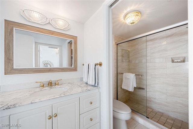 bathroom with a stall shower, vanity, and toilet