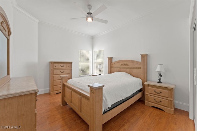 bedroom with light wood-style floors, ornamental molding, baseboards, and a ceiling fan