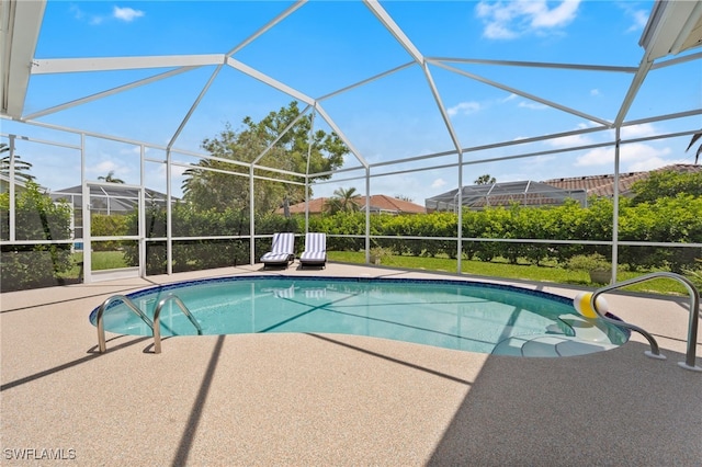 pool with a patio area and glass enclosure