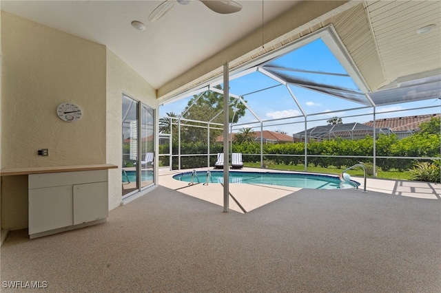 pool with ceiling fan, a patio, and glass enclosure
