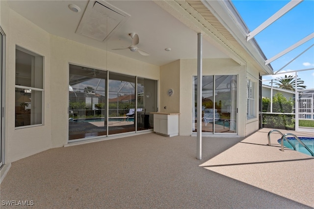 view of patio / terrace with glass enclosure, ceiling fan, and an outdoor pool