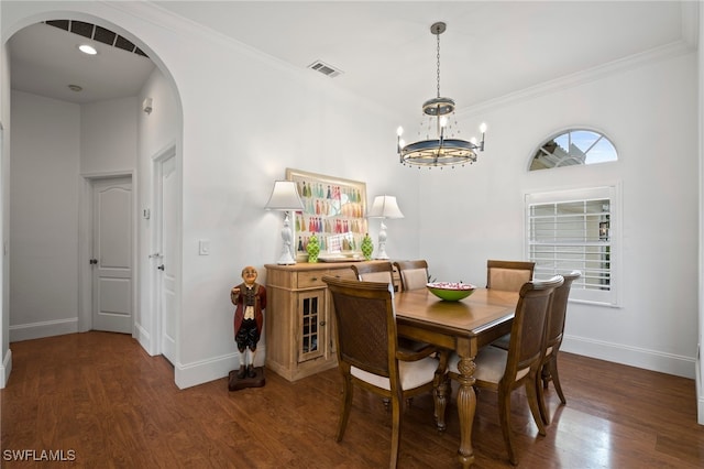 dining space with arched walkways, wood finished floors, visible vents, and baseboards