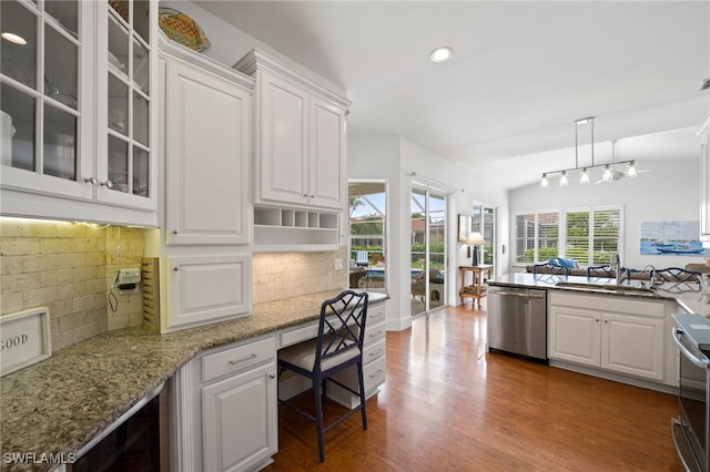 kitchen featuring white cabinetry, appliances with stainless steel finishes, built in desk, dark wood finished floors, and glass insert cabinets