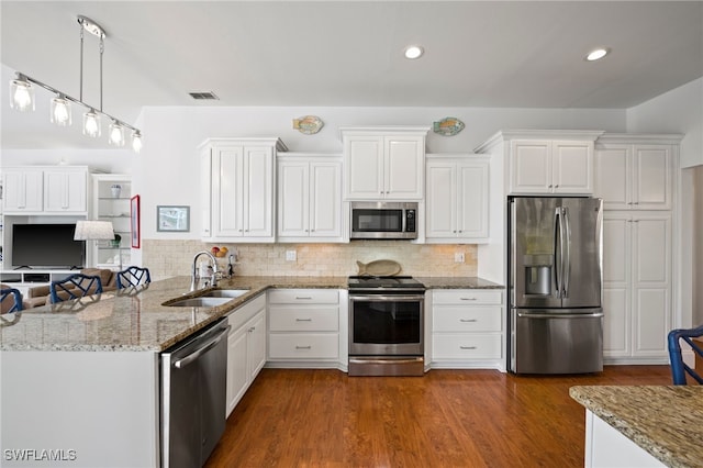 kitchen featuring appliances with stainless steel finishes, white cabinets, and a sink