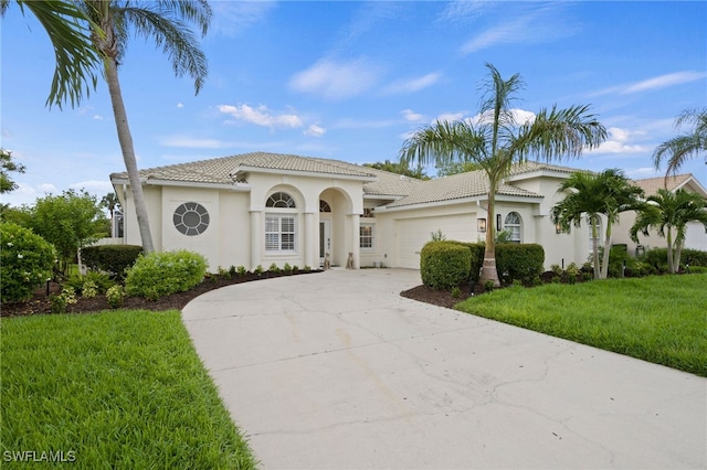 mediterranean / spanish-style house featuring a garage, a tile roof, driveway, and stucco siding