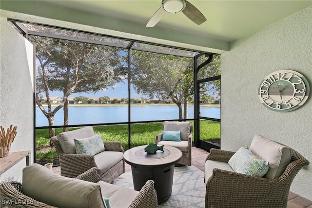 sunroom / solarium with a ceiling fan and a water view