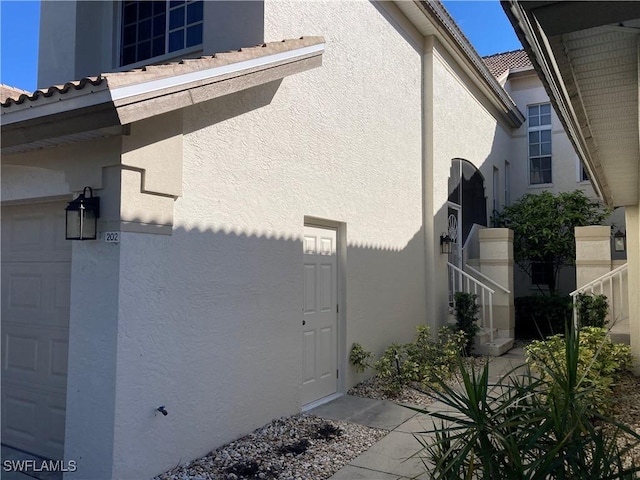 view of property exterior with a tiled roof and stucco siding