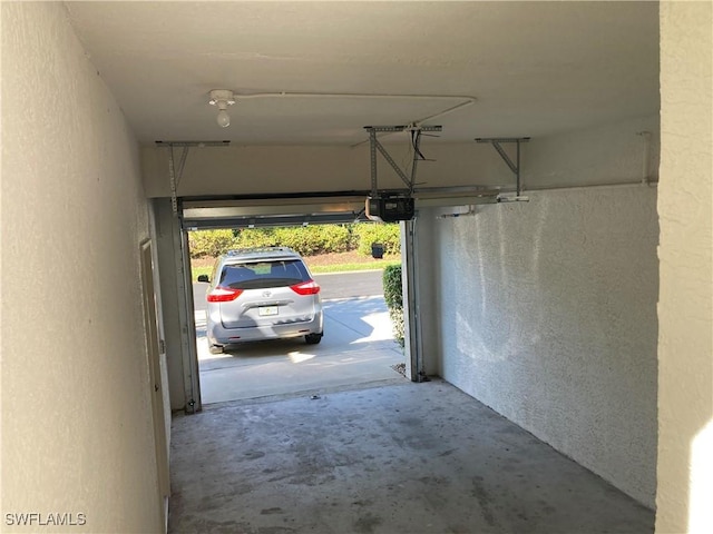 garage with a textured wall and a garage door opener