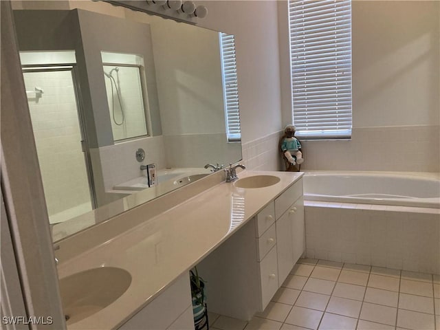 bathroom featuring tile patterned flooring, a garden tub, a sink, and double vanity