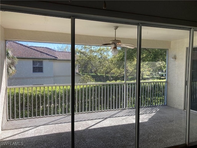 unfurnished sunroom featuring plenty of natural light and a ceiling fan