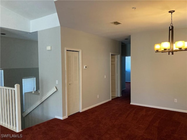 unfurnished room featuring baseboards, visible vents, and dark carpet