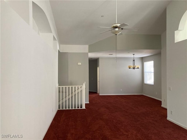 unfurnished room with ceiling fan with notable chandelier, dark colored carpet, and baseboards