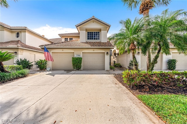 mediterranean / spanish home with stucco siding, concrete driveway, an attached garage, and a tile roof