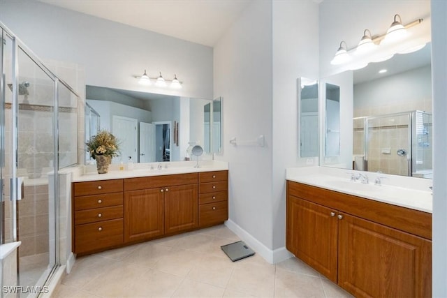 bathroom with a shower stall, a sink, and tile patterned floors