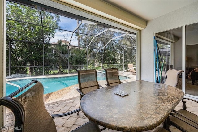 exterior space with a lanai, a patio area, and a pool with connected hot tub