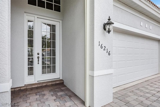 property entrance with french doors and stucco siding