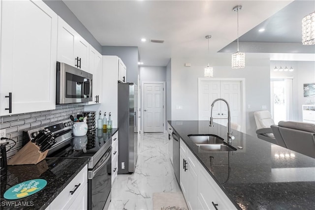 kitchen with white cabinets, decorative backsplash, marble finish floor, stainless steel appliances, and a sink