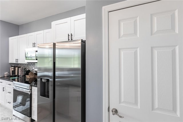 kitchen with dark countertops, white cabinetry, appliances with stainless steel finishes, and tasteful backsplash