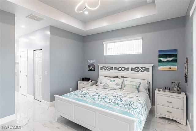 bedroom featuring marble finish floor, a tray ceiling, visible vents, and baseboards