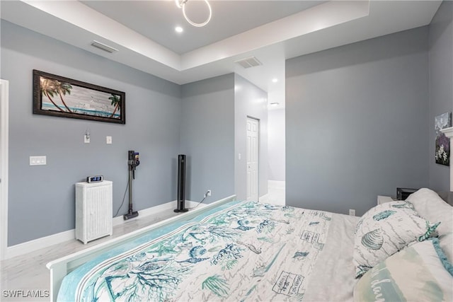 bedroom with recessed lighting, a raised ceiling, visible vents, and baseboards