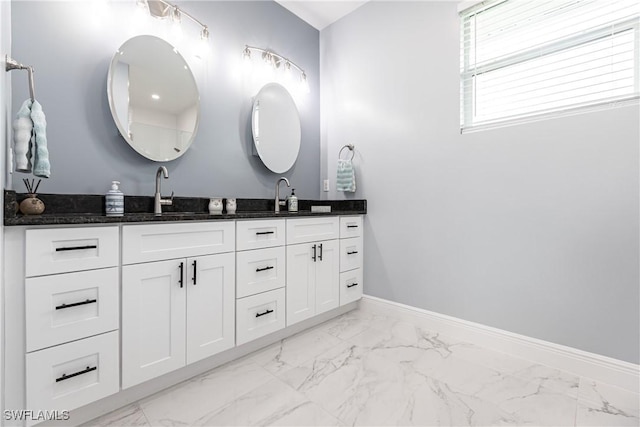 full bath with marble finish floor, a sink, baseboards, and double vanity