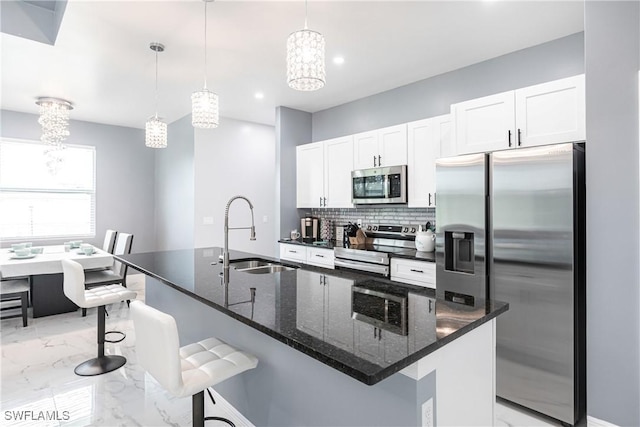 kitchen with marble finish floor, stainless steel appliances, a kitchen bar, and a sink