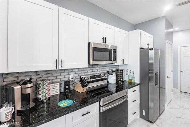 kitchen featuring stainless steel appliances, visible vents, marble finish floor, backsplash, and dark stone counters