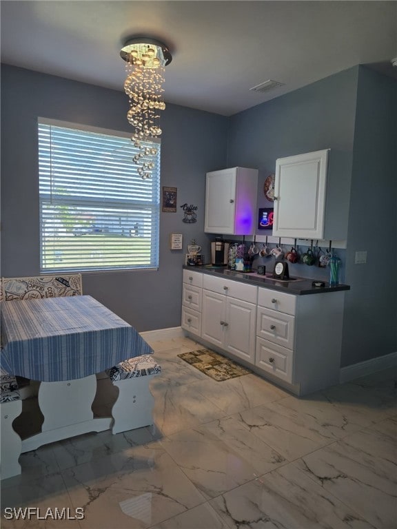 interior space with marble finish floor, baseboards, visible vents, and vanity