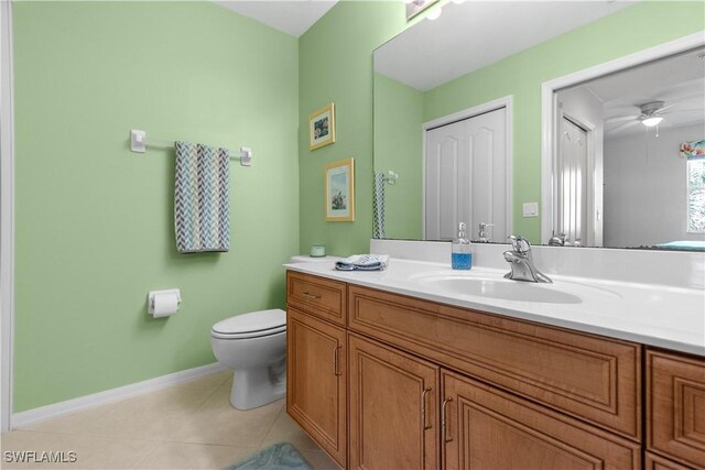 bathroom with toilet, ceiling fan, vanity, tile patterned flooring, and baseboards