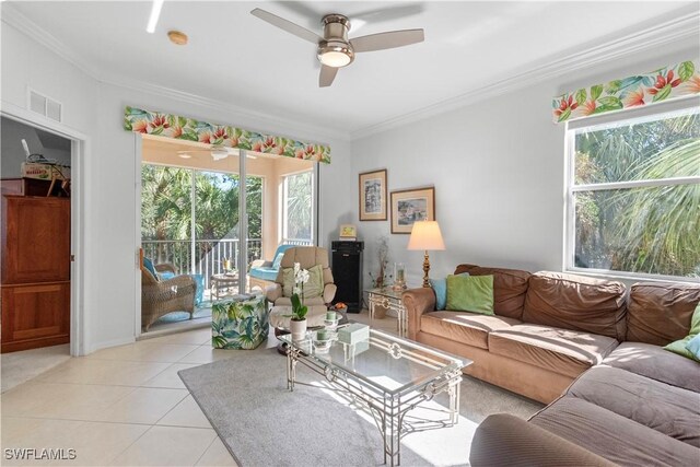 living area featuring a healthy amount of sunlight, light tile patterned floors, visible vents, and ornamental molding