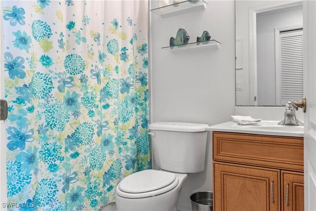 bathroom with toilet, a shower with shower curtain, and vanity