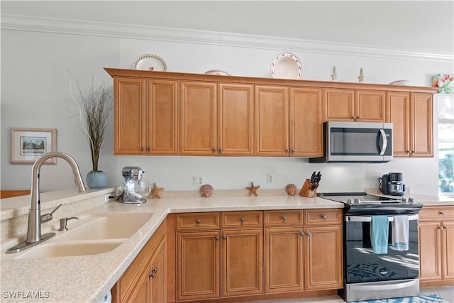 kitchen with brown cabinets, stainless steel appliances, crown molding, light countertops, and a sink