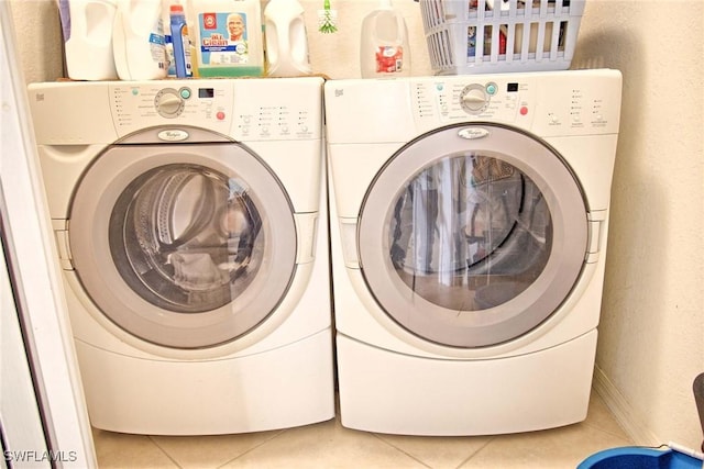 laundry area featuring laundry area, light tile patterned floors, and washing machine and clothes dryer