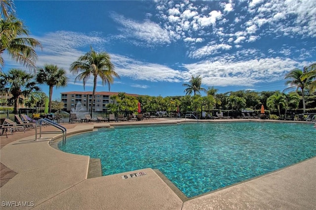 pool with a patio and fence