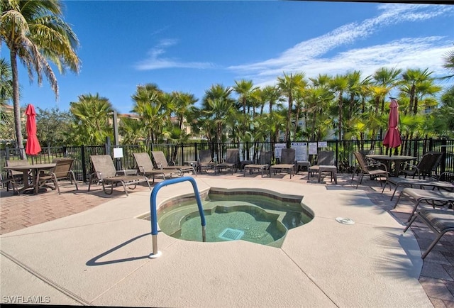 view of swimming pool with a community hot tub, a patio, and fence