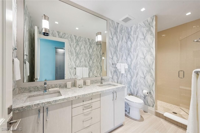 full bath featuring a sink, a stall shower, and wallpapered walls