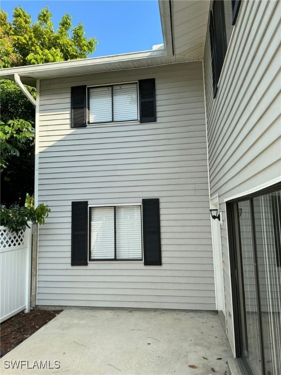 view of side of property with fence and a patio