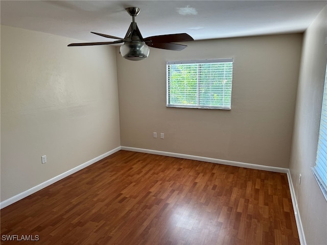 empty room with ceiling fan, baseboards, and wood finished floors