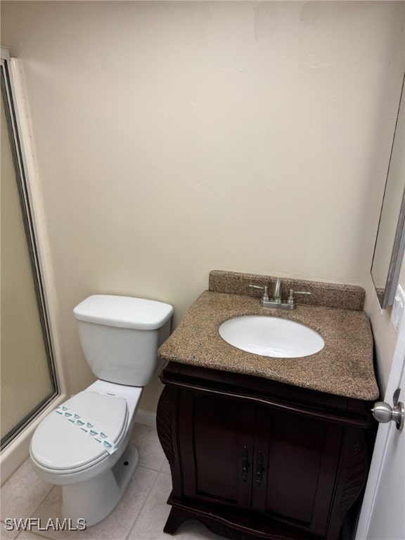 full bathroom featuring toilet, tile patterned flooring, vanity, and a shower stall