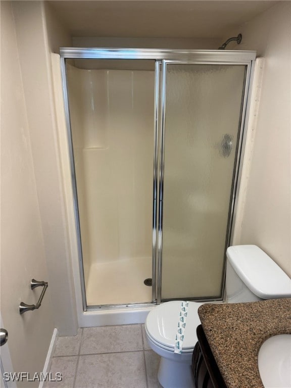 full bath featuring toilet, an enclosed shower, tile patterned flooring, and vanity