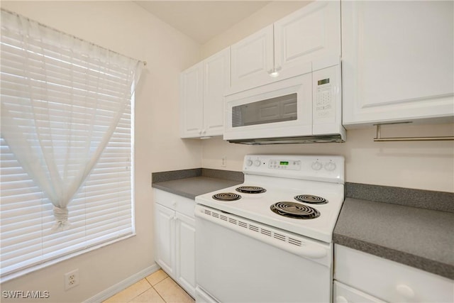 kitchen with dark countertops, white appliances, and white cabinets