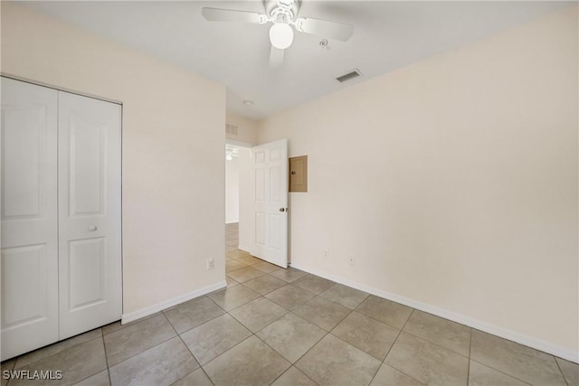 unfurnished bedroom with light tile patterned floors, baseboards, visible vents, and a closet