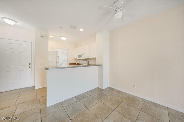 kitchen featuring a ceiling fan, white cabinetry, light tile patterned flooring, white appliances, and baseboards