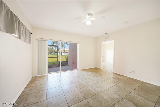 empty room with a ceiling fan, baseboards, and light tile patterned floors